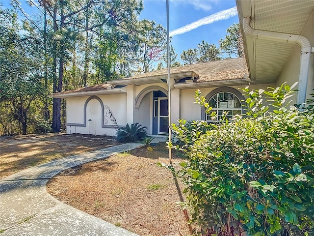 property entrance featuring driveway and stucco siding