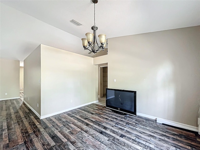 interior space with a chandelier, wood finished floors, visible vents, and baseboards