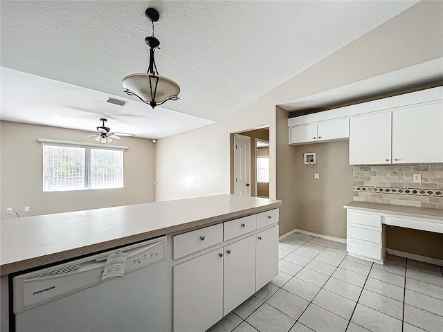 kitchen with tasteful backsplash, white cabinets, hanging light fixtures, white dishwasher, and light countertops