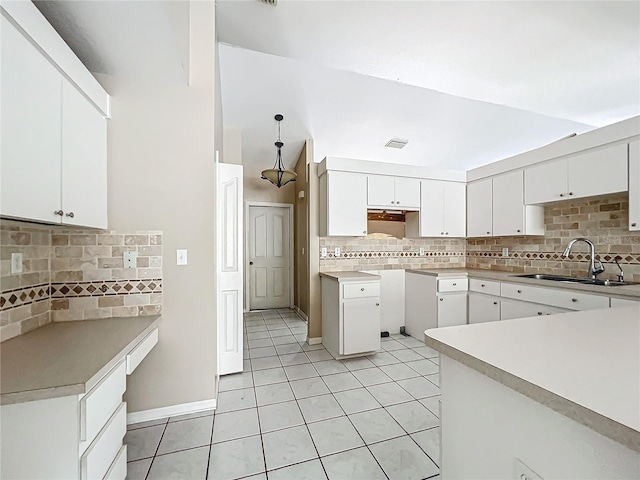 kitchen featuring light tile patterned floors, tasteful backsplash, visible vents, white cabinetry, and a sink