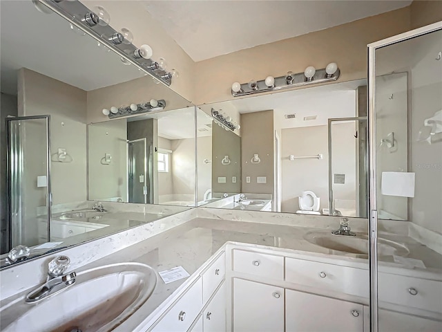 full bathroom with double vanity, a stall shower, and a sink