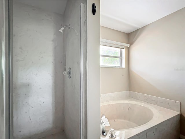 bathroom featuring a stall shower and a garden tub