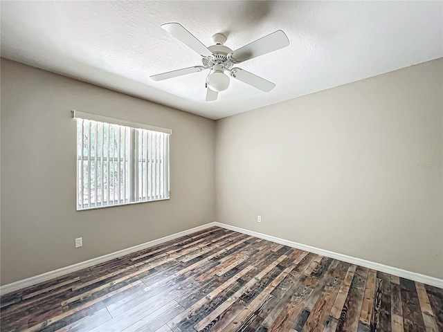 spare room featuring a ceiling fan, dark wood-style flooring, a textured ceiling, and baseboards