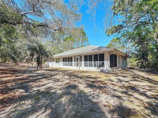 rear view of property featuring a sunroom