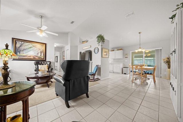 living room featuring light tile patterned floors, vaulted ceiling, ceiling fan with notable chandelier, and visible vents