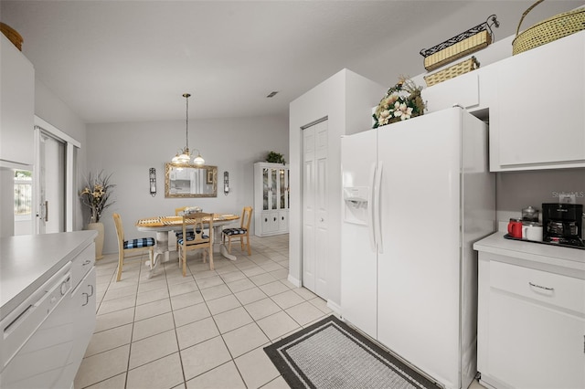 kitchen with light countertops, hanging light fixtures, light tile patterned flooring, white cabinets, and white appliances