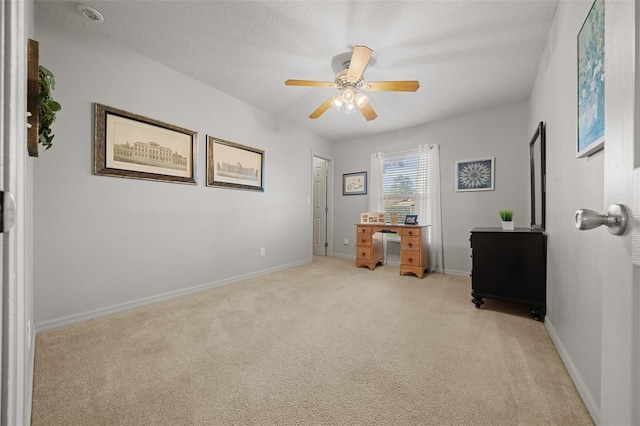 interior space featuring a ceiling fan, light colored carpet, a textured ceiling, and baseboards