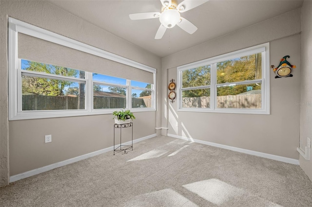 empty room featuring carpet floors, a ceiling fan, and baseboards