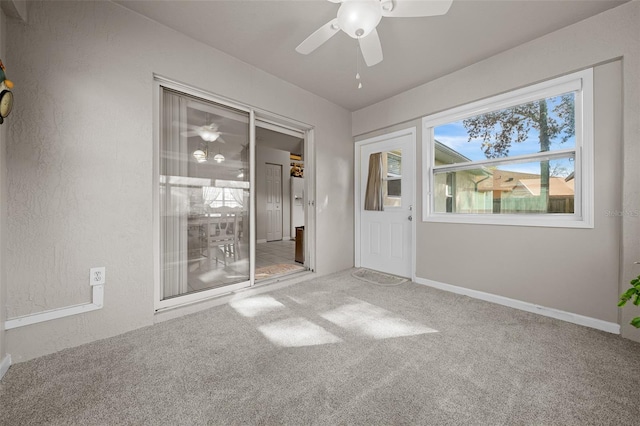 unfurnished room featuring ceiling fan, a textured wall, carpet, and baseboards