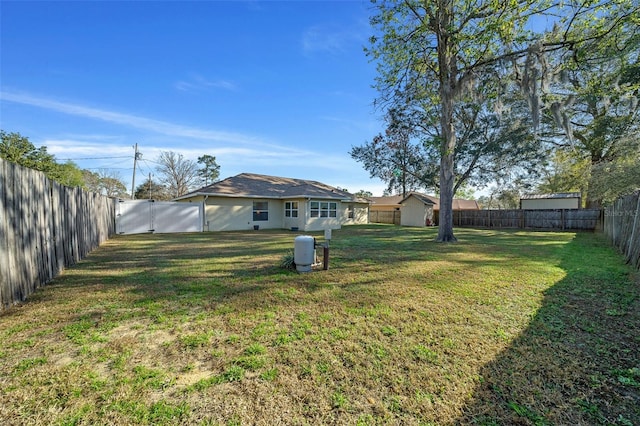 view of yard featuring a fenced backyard and a gate