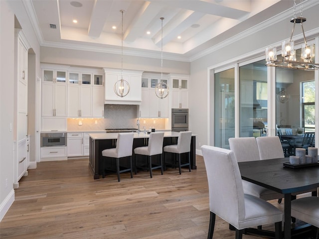 dining room featuring light wood-type flooring, beam ceiling, visible vents, crown molding, and a chandelier