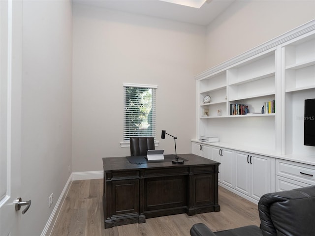 office area with baseboards and light wood finished floors