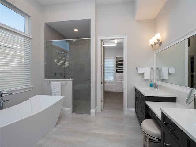 full bath with a soaking tub, vanity, a shower stall, and tile patterned floors