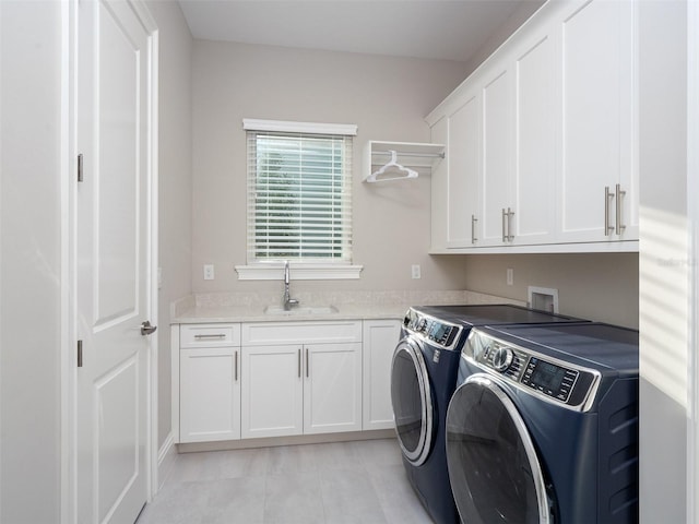 clothes washing area featuring cabinet space, light tile patterned floors, washing machine and dryer, and a sink