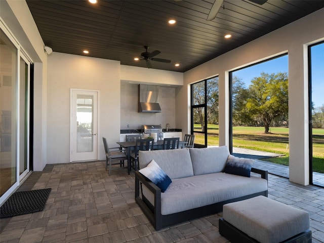 view of patio featuring a ceiling fan, an outdoor living space, area for grilling, outdoor dining area, and exterior kitchen