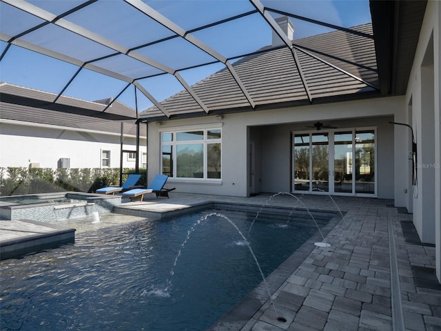 pool featuring glass enclosure, a jacuzzi, a patio area, and ceiling fan