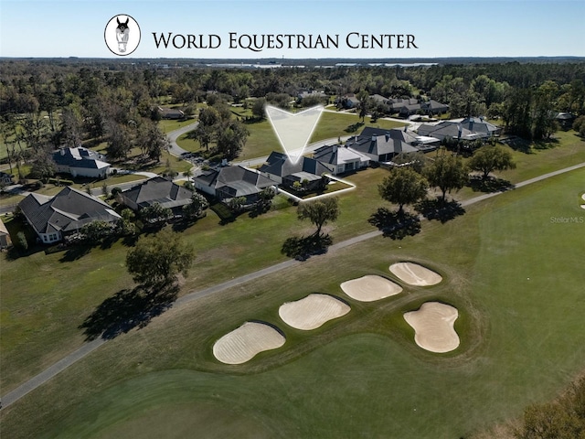 drone / aerial view featuring golf course view, a forest view, and a residential view