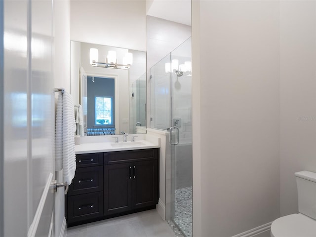 bathroom featuring vanity, tile patterned floors, toilet, and a stall shower