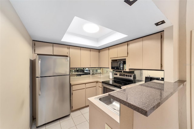 kitchen featuring appliances with stainless steel finishes, a raised ceiling, a peninsula, and cream cabinets