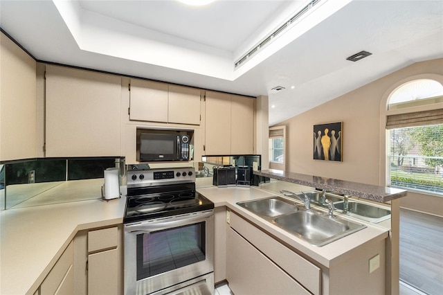 kitchen featuring black microwave, a peninsula, a sink, vaulted ceiling, and stainless steel electric range