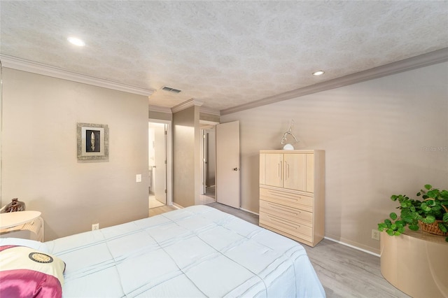 bedroom featuring visible vents, light wood-style flooring, ornamental molding, a textured ceiling, and baseboards