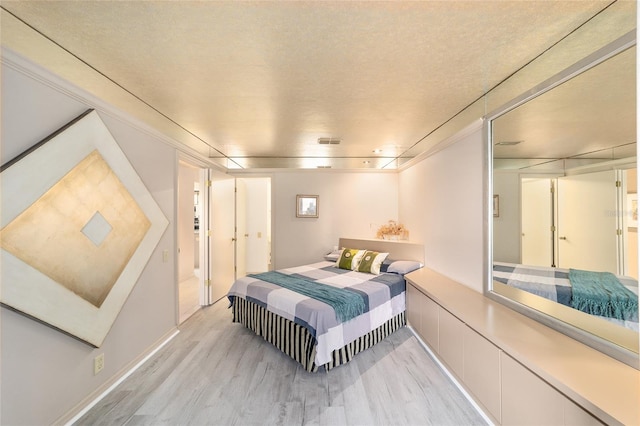 bedroom with light wood-type flooring and visible vents