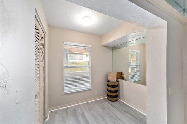 interior space featuring a closet, baseboards, and wood finished floors