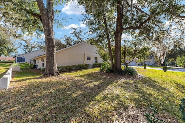 view of side of property with a yard and stucco siding