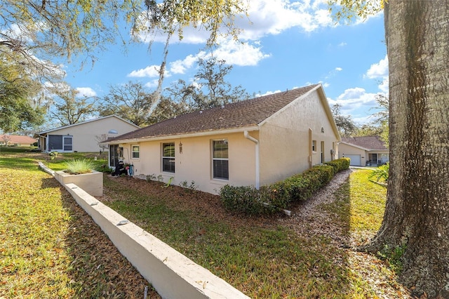 view of side of home featuring a yard and stucco siding