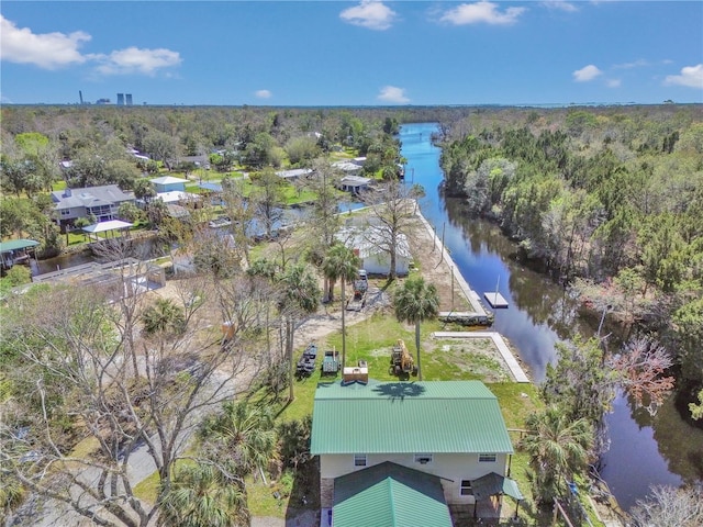 birds eye view of property with a water view and a wooded view