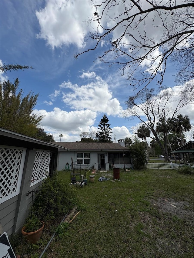 back of property featuring a yard and fence