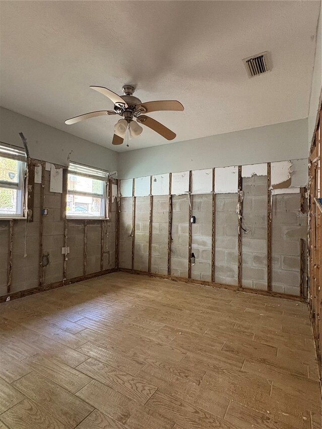 spare room featuring visible vents, ceiling fan, and wood finished floors