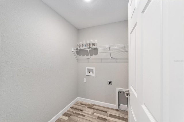 clothes washing area with washer hookup, light wood-style floors, electric dryer hookup, laundry area, and baseboards