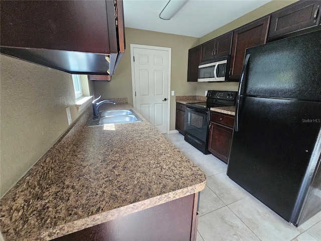 kitchen featuring black appliances, dark brown cabinets, light tile patterned flooring, and a sink