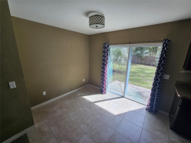 spare room featuring tile patterned flooring and baseboards