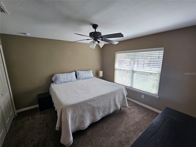 carpeted bedroom featuring a textured ceiling, ceiling fan, and baseboards