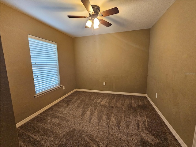 carpeted spare room featuring a ceiling fan and baseboards