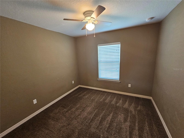 empty room with a textured ceiling, ceiling fan, dark carpet, and baseboards