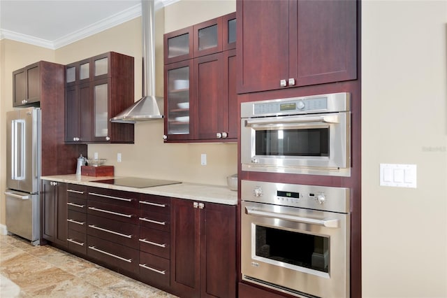 kitchen featuring appliances with stainless steel finishes, wall chimney range hood, reddish brown cabinets, glass insert cabinets, and crown molding