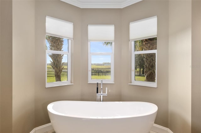 full bath featuring a soaking tub, a sink, and baseboards