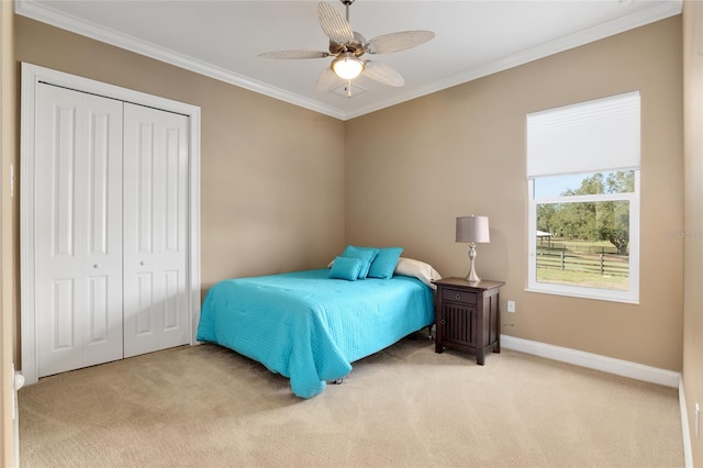 bedroom with baseboards, a closet, carpet, and crown molding