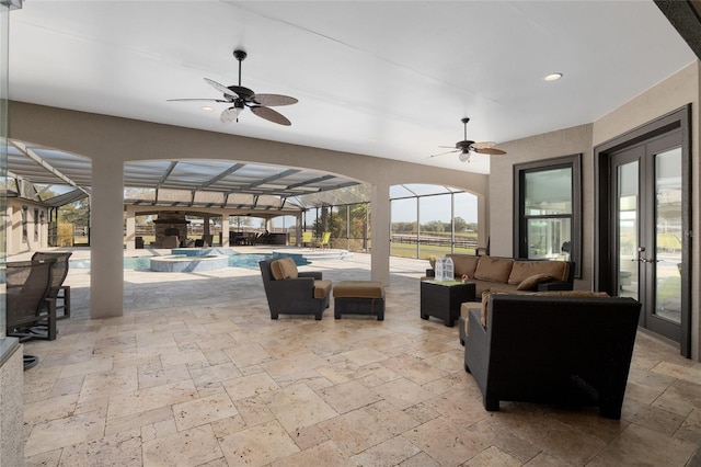 view of patio featuring a lanai, a pool with connected hot tub, a ceiling fan, and french doors