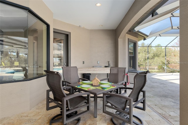 view of patio featuring glass enclosure and outdoor dining area