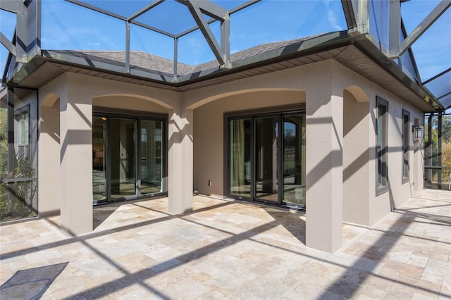 back of property with a lanai, a patio area, roof with shingles, and stucco siding