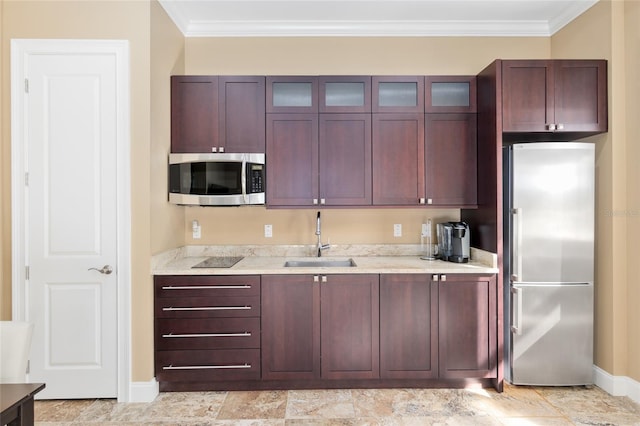 kitchen featuring appliances with stainless steel finishes, a sink, glass insert cabinets, and crown molding