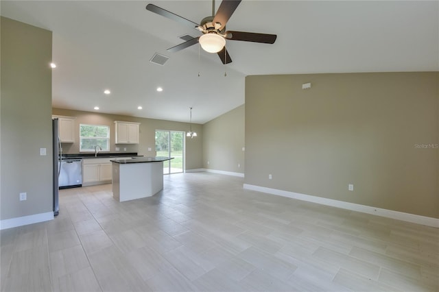 kitchen featuring dark countertops, visible vents, open floor plan, a sink, and dishwasher