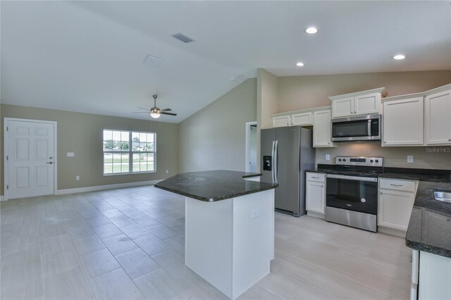 kitchen featuring stainless steel appliances, visible vents, open floor plan, white cabinetry, and dark stone countertops