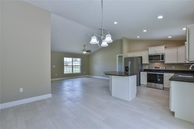 kitchen with stainless steel appliances, open floor plan, white cabinetry, a sink, and a kitchen island