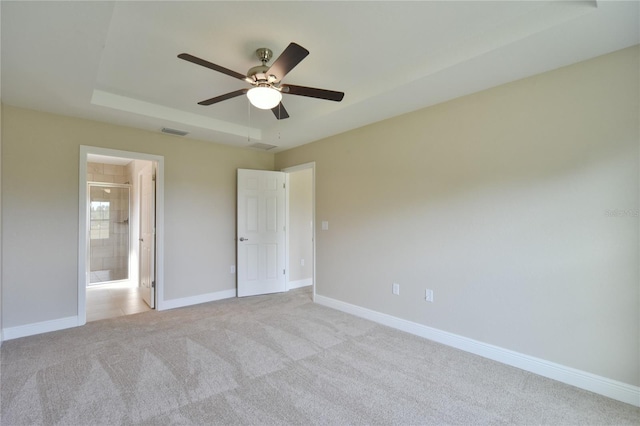 unfurnished bedroom with ceiling fan, connected bathroom, light colored carpet, visible vents, and baseboards