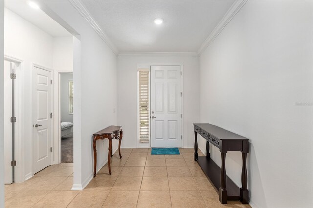 entrance foyer with crown molding, baseboards, and light tile patterned floors